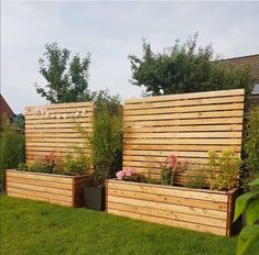 two wooden planters sitting on top of a lush green field