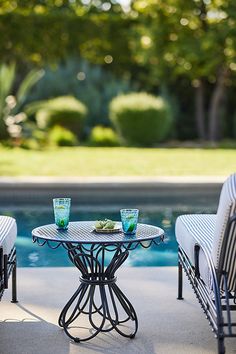 two chairs and a table near a pool