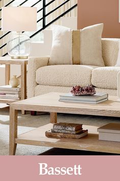 a coffee table with books on it in front of a couch and stair railings