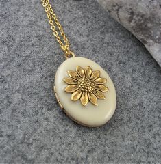 Gold Plated Cream Sunflower Locket. Gift For Women. Gold necklace pendant with a beautiful Cream enamel and two spaces inside for photos etc. This beautiful locket would make a perfect gift for birthdays, anniversaries, etc. The locket is hanging on a gold plated chain and you can choose your length at checkout. Measurements are 30 mm long, 25mm wide. Your locket will be gift boxed. All lockets are made to order, if you have a special requirement please let me know. Thank you for visiting my sho Elegant Locket Necklace With Flower Charm As Gift, Elegant Vintage Charm Jewelry For Anniversary Gift, Vintage Round Jewelry Gift For Mom, Vintage Flower Shape Personalized Jewelry, Vintage Personalized Flower Jewelry, Vintage Personalized Flower-shaped Jewelry, Vintage Flower Jewelry Keepsake, Elegant Flower Charm Locket Necklace For Anniversary, Personalized Vintage Flower Jewelry