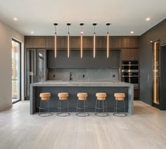 a kitchen with an island and four stools in front of the countertop area