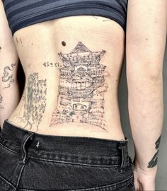 a woman with tattoos on her stomach has a piece of paper in the shape of a castle