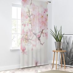 a window with pink flowers on it next to a potted plant in front of the window