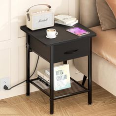 a small table with a radio on it next to a couch and coffee cup in the corner