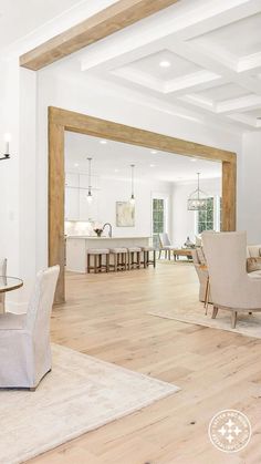 a living room filled with furniture next to a dining room table and chairs on top of a hard wood floor