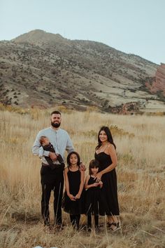 a family poses for a photo in front of a mountain