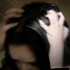 a blurry image of a woman's head with her hair in the air