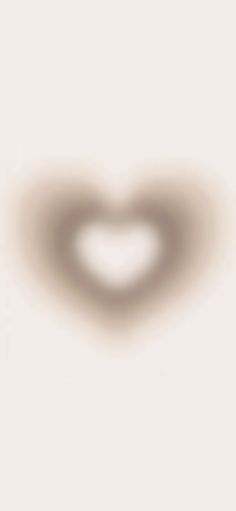 a blurry image of a heart shaped object on a white background with the light reflecting off it's side