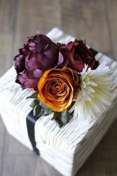 a bouquet of flowers sitting on top of a white box