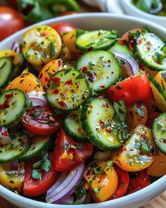 a white bowl filled with cucumbers, tomatoes and onions on top of a wooden table