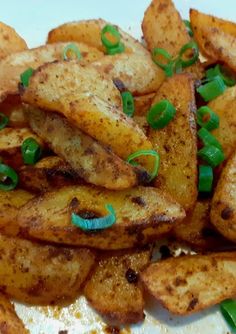 some fried potatoes with green onions and seasoning on top