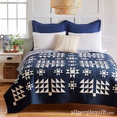 a blue and white quilted bed with pillows