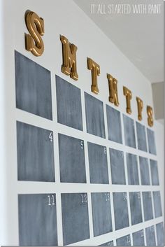 a white wall with gold letters and numbers on it