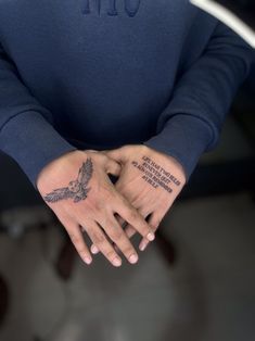 a person with a tattoo on their arm holding his hands in front of the camera