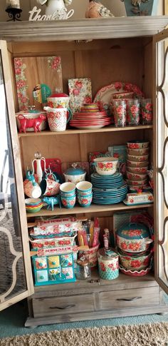 an old china cabinet filled with dishes and bowls