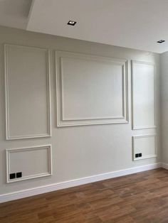 an empty room with white walls and wood floors