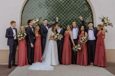 a group of people standing next to each other in front of a building with flowers