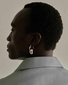 a woman with short black hair wearing earrings