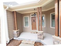 a front porch with steps leading up to the door and windows on either side of the house