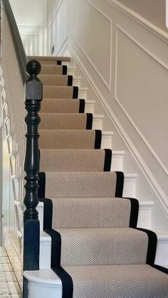 the stairs are lined with black and white carpet