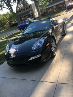 a black sports car parked in front of a house