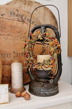 a candle sits on top of a table next to an old wooden box and spools of thread