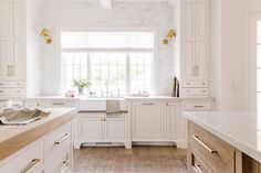 an image of a kitchen setting with white cabinets and marble counter tops on the website page