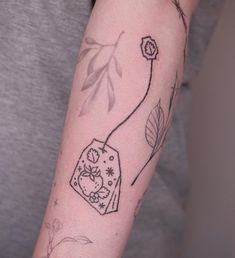 a person with a tattoo on their arm holding a cell phone in one hand and a flower in the other