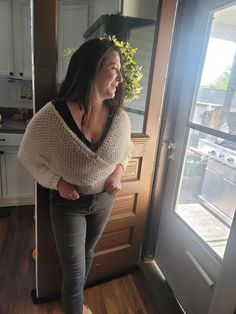 a woman standing in front of a door with her hands on her hips and looking out the window