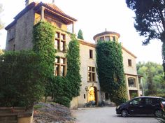 a car parked in front of a large building with ivy growing on it's walls