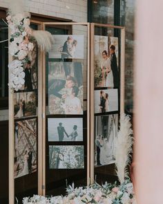 an outdoor wedding photo booth with flowers and pictures on the wall in front of it