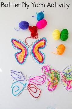 colorful yarn and crochet butterflies on a white surface