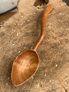 a wooden spoon sitting on top of a piece of wood