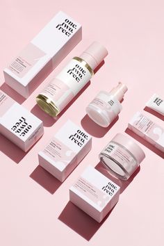 the skin care products are laid out on a pink surface and placed next to each other