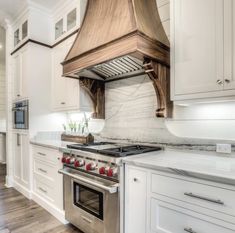 a stove top oven sitting inside of a kitchen next to white cabinets and counter tops