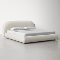 a white bed sitting on top of a gray floor