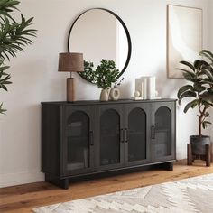 a living room with a large mirror on the wall and a black cabinet in front of it