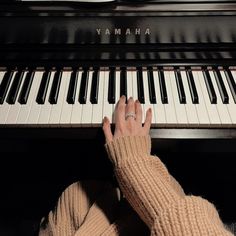 a person's hand resting on the piano keys