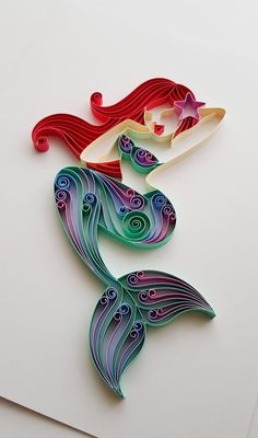 two paper cut out of the shape of a mermaid and a surfboard