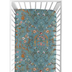 a baby crib with a blue floral print on it