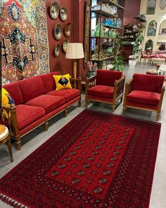 a living room filled with red couches and rugs on the floor next to each other