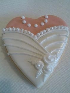 a heart shaped cookie with white and pink decorations