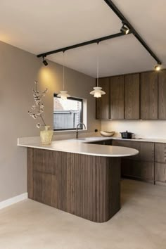 a large kitchen with an island in the center and wooden cabinets on both sides, along with white counter tops