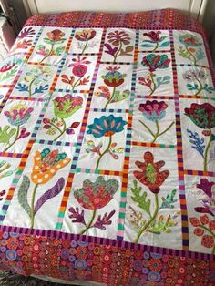 a quilted bed with colorful flowers on it