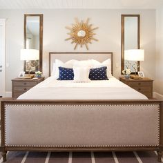 a bedroom with a large bed and two lamps on either side of the headboard