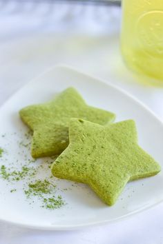 two green star shaped cookies on a white plate