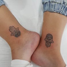 two people with matching tattoos on their legs, one has a hamsa and the other has a hand