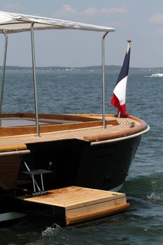 a boat with a flag on it floating in the water