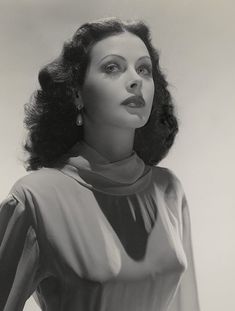 black and white photograph of a woman with her hair blowing in the wind, wearing a collared blouse