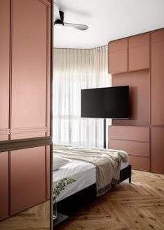 a bedroom with pink cabinets and a flat screen tv mounted on the wall above it